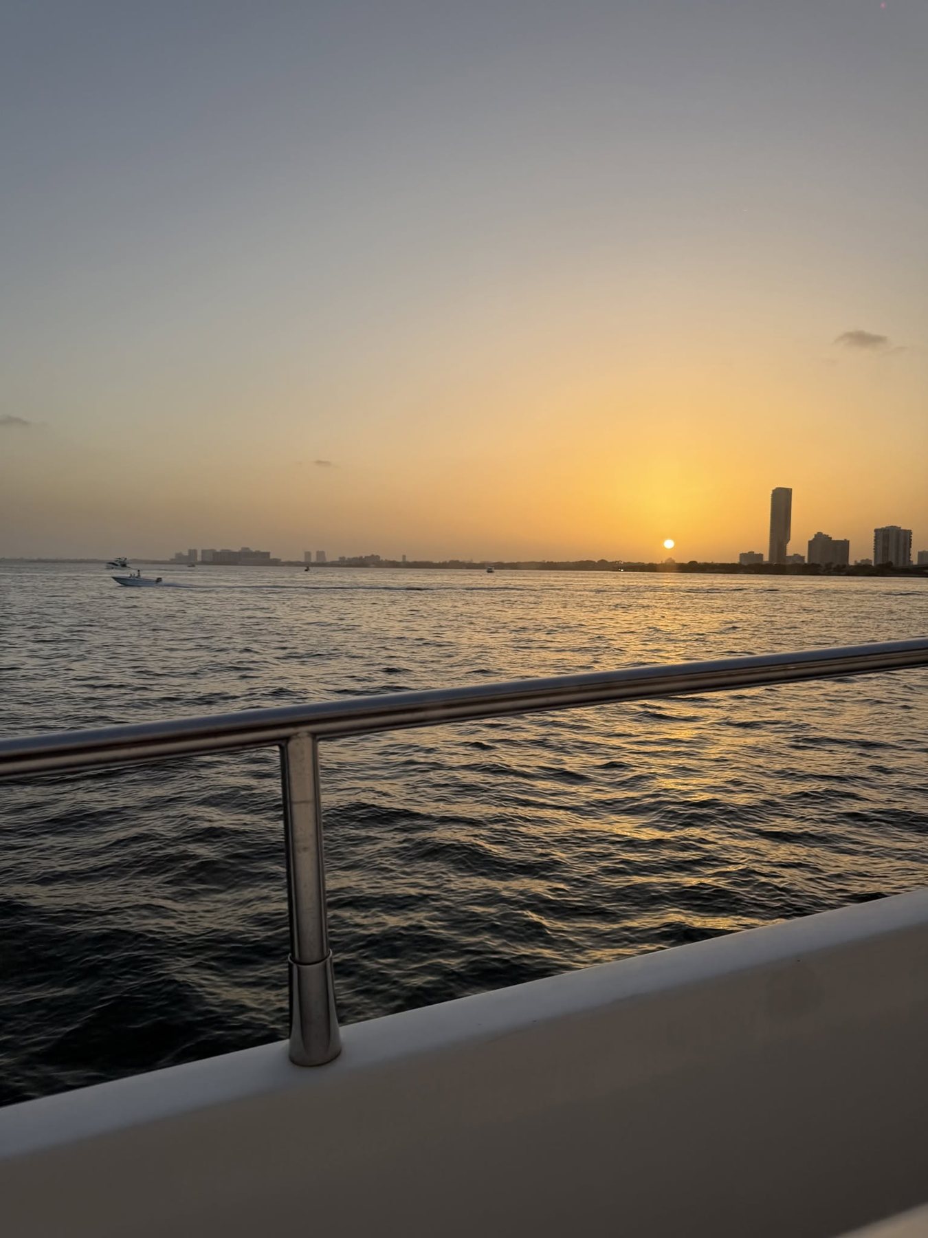 Sunset over the water from the yacht rail